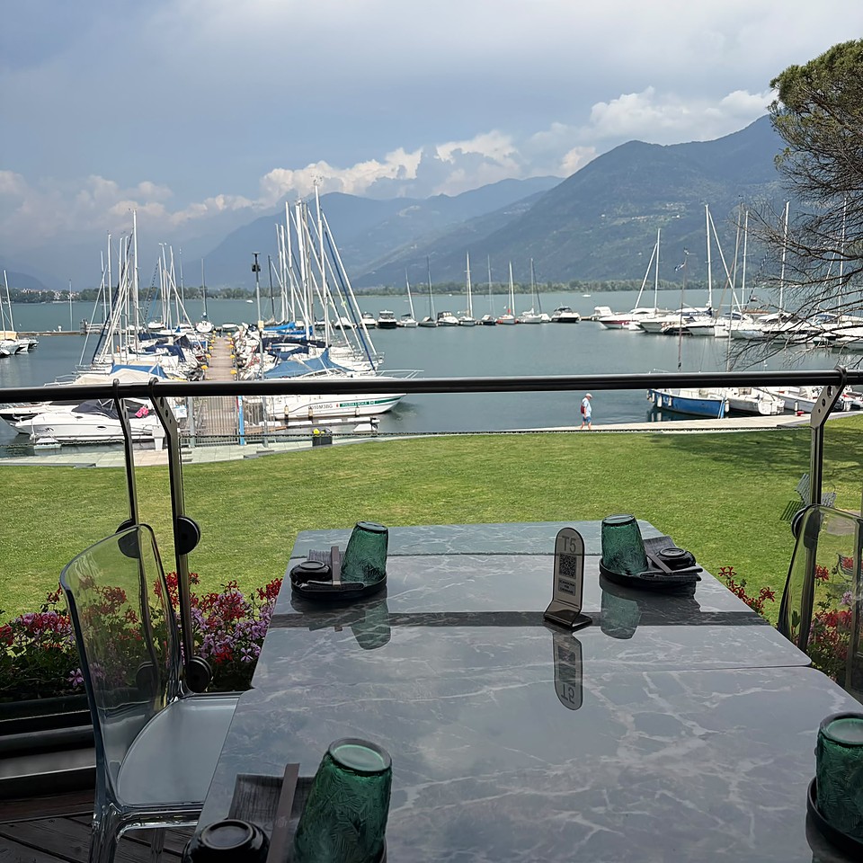 La vista sul porto di Lovere e sul Lago d'Iseo, con le barche a vela e le montagne, dal tavolo di Yotto