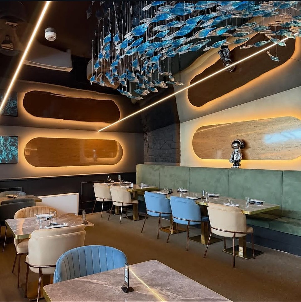 L'installazione di pesci in vetro sospesa sul soffitto della sala